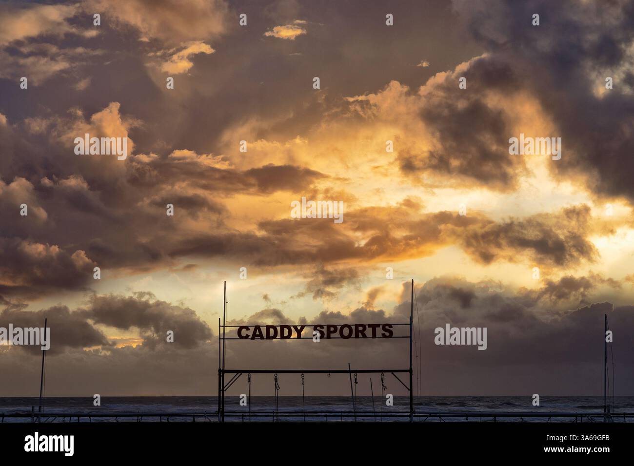 Vista di un suggestivo paesaggio nuvoloso e cartello Caddy Sports sulla spiaggia di le Touquet in serata. Le Touquet Paris Plage, Francia Foto Stock