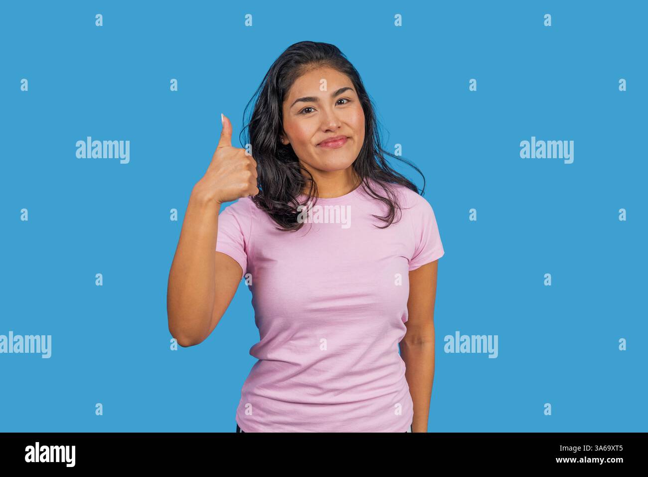 Una donna felice e informale che gestisce il pollice in segno di approvazione, come accordo, successo, buon lavoro, feedback positivo Foto Stock