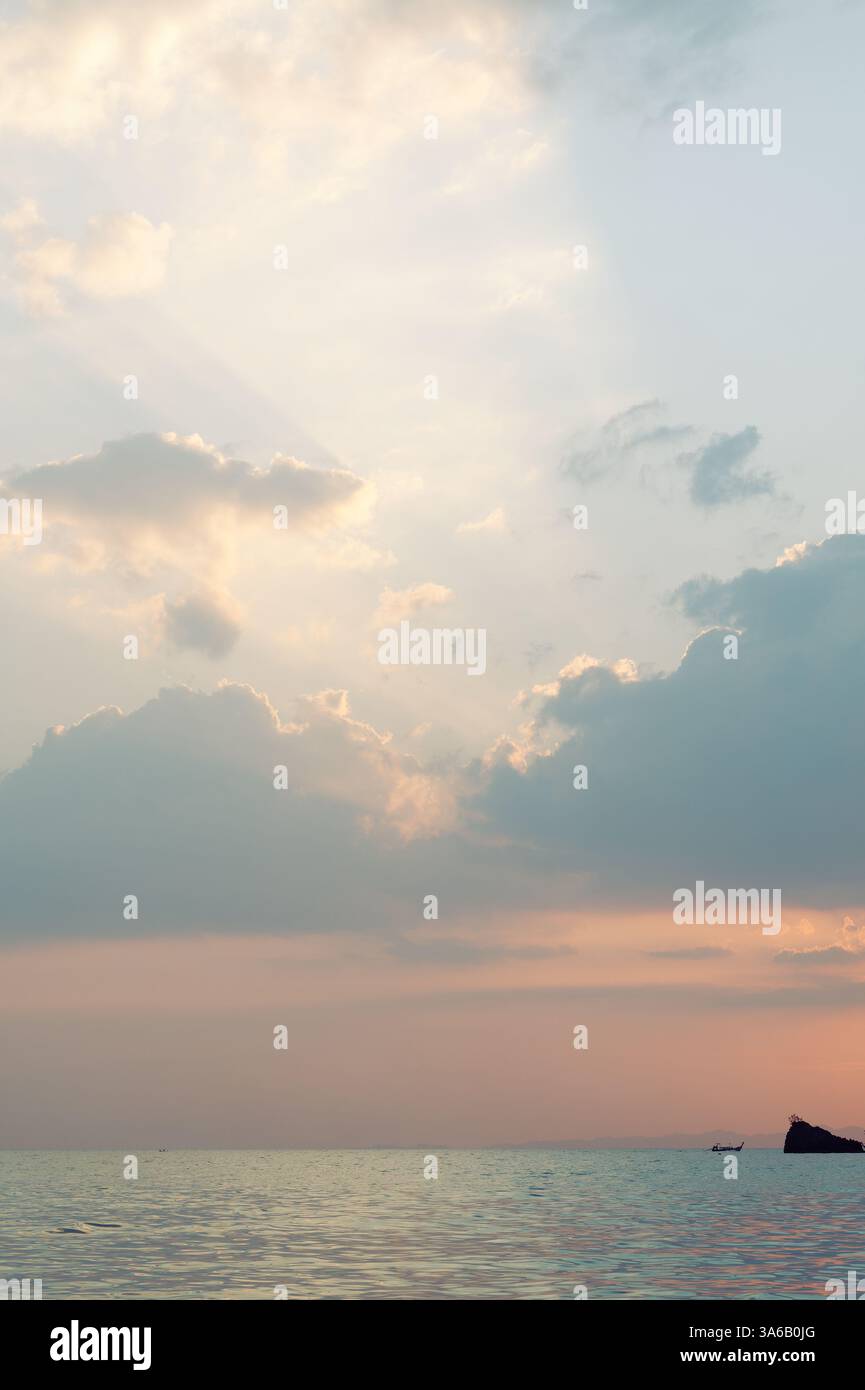 Un cielo al tramonto dai toni pastello sul mare di Tonsai, con barche a coda lunga che si spostano in lontananza Foto Stock
