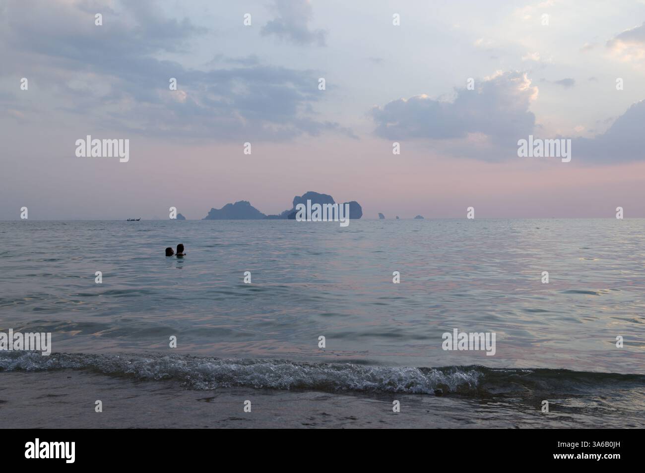 Due nuotatori si godono le calme acque di Tonsai Beach al tramonto Foto Stock