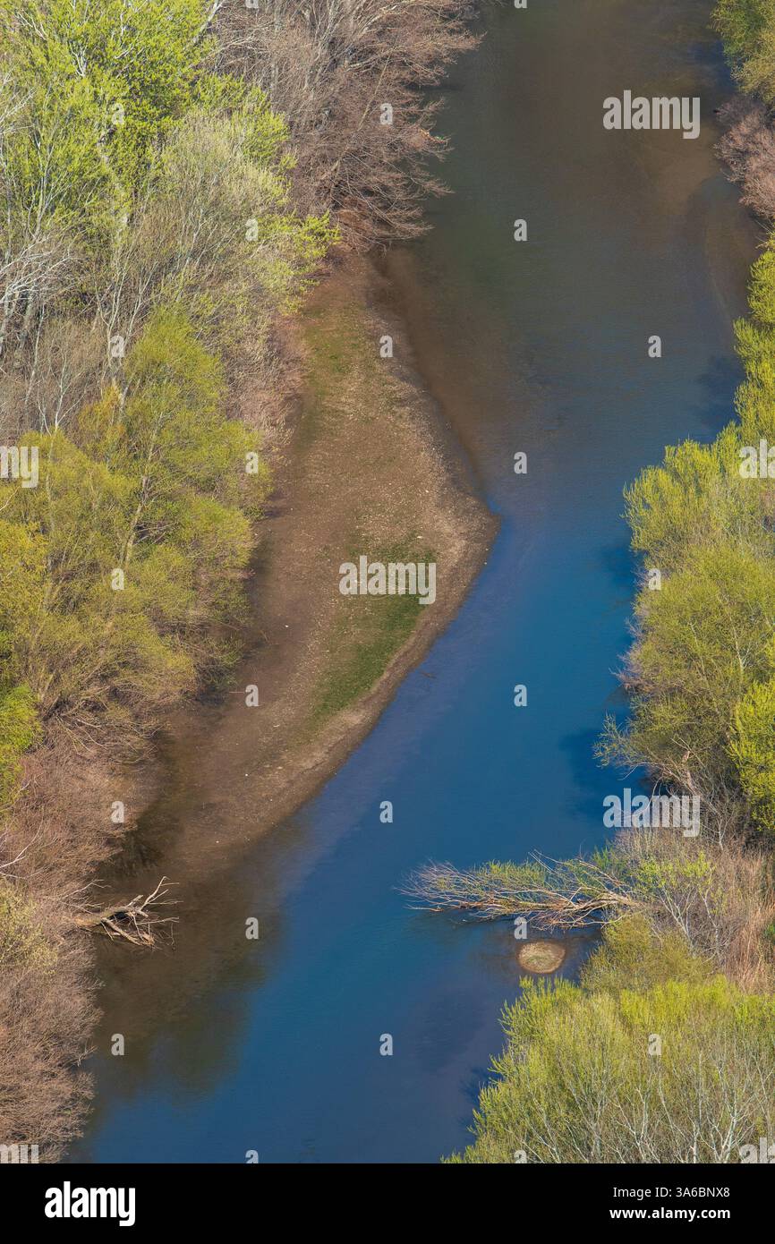 Spring Flow – fiume incorniciato da alberi verdi Foto Stock