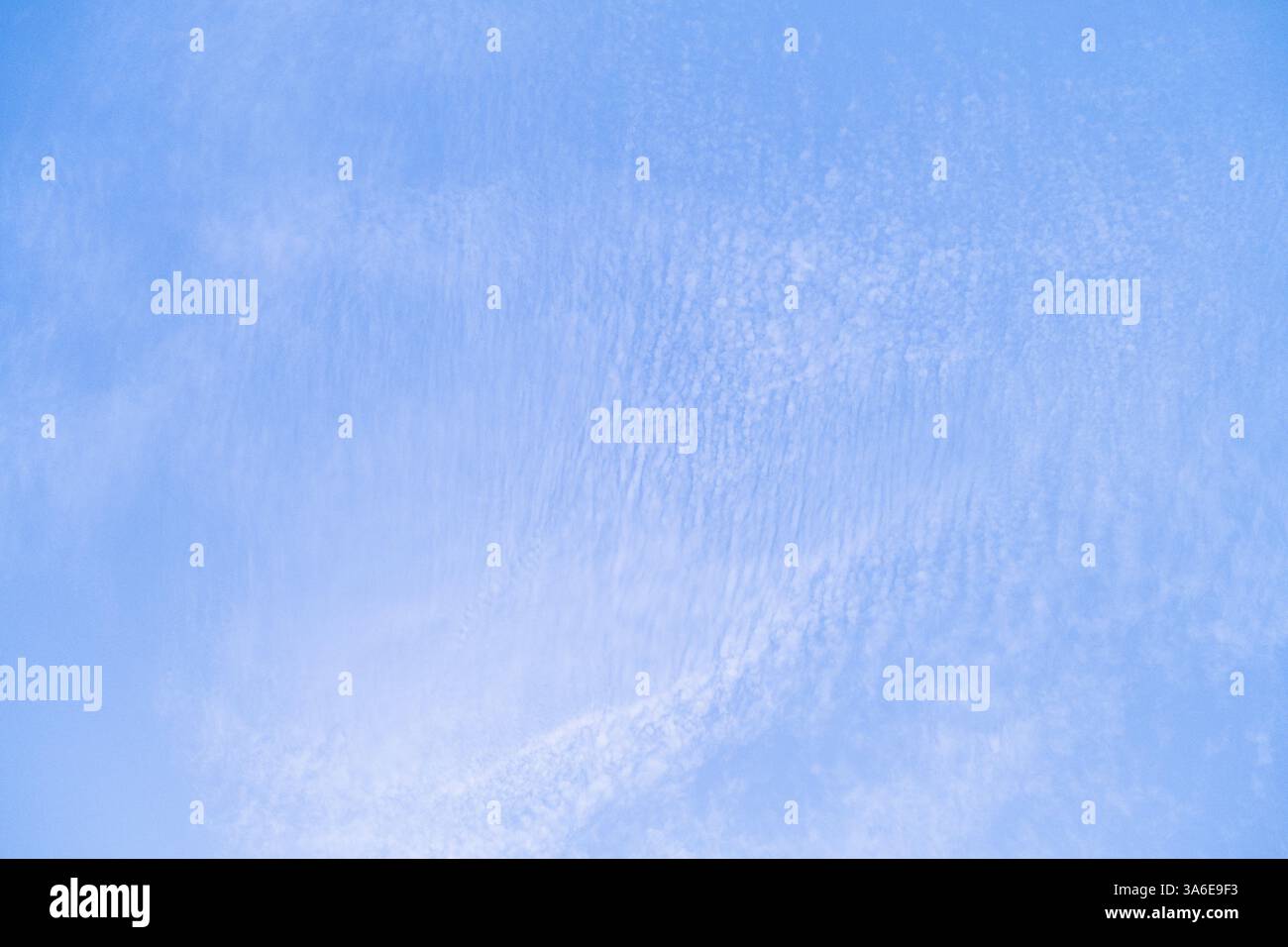Paesaggio del cielo sulla costa della Spagna meridionale. Ci sono piccole nuvole e il tramonto dona un particolare colore pastello. I toni sono bianchi e blu. Foto Stock