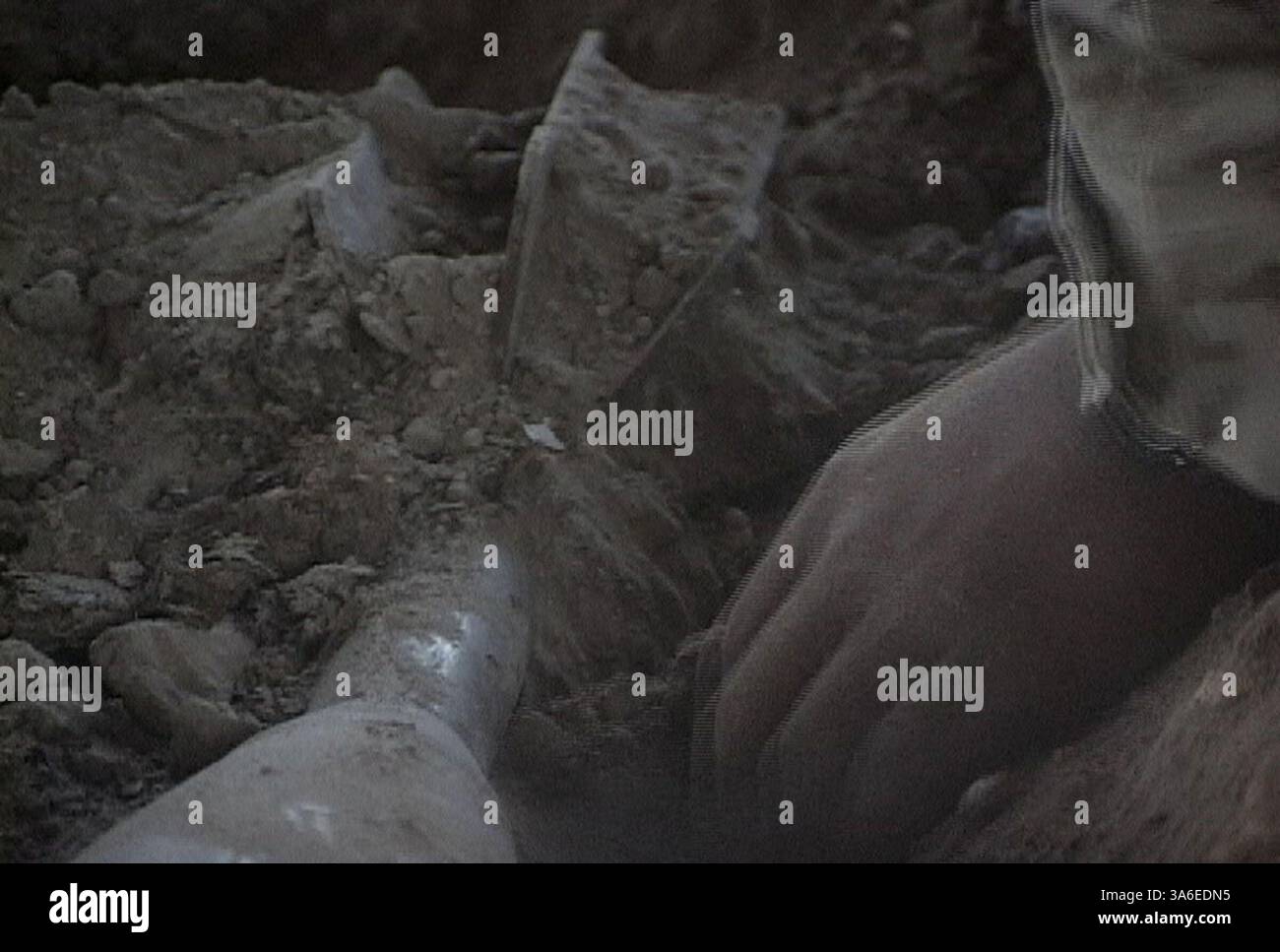 18 agosto 2004; AR Ramadi, Iraq; Un ingegnere dei Marines con il 2nd Battalion, il 4th Marine Regiment scava un colpo di mortaio da 160 mm da un deposito di armi nascosto in un fienile durante l'operazione Showdown ad AR Ramadi, 18 agosto. Foto Stock