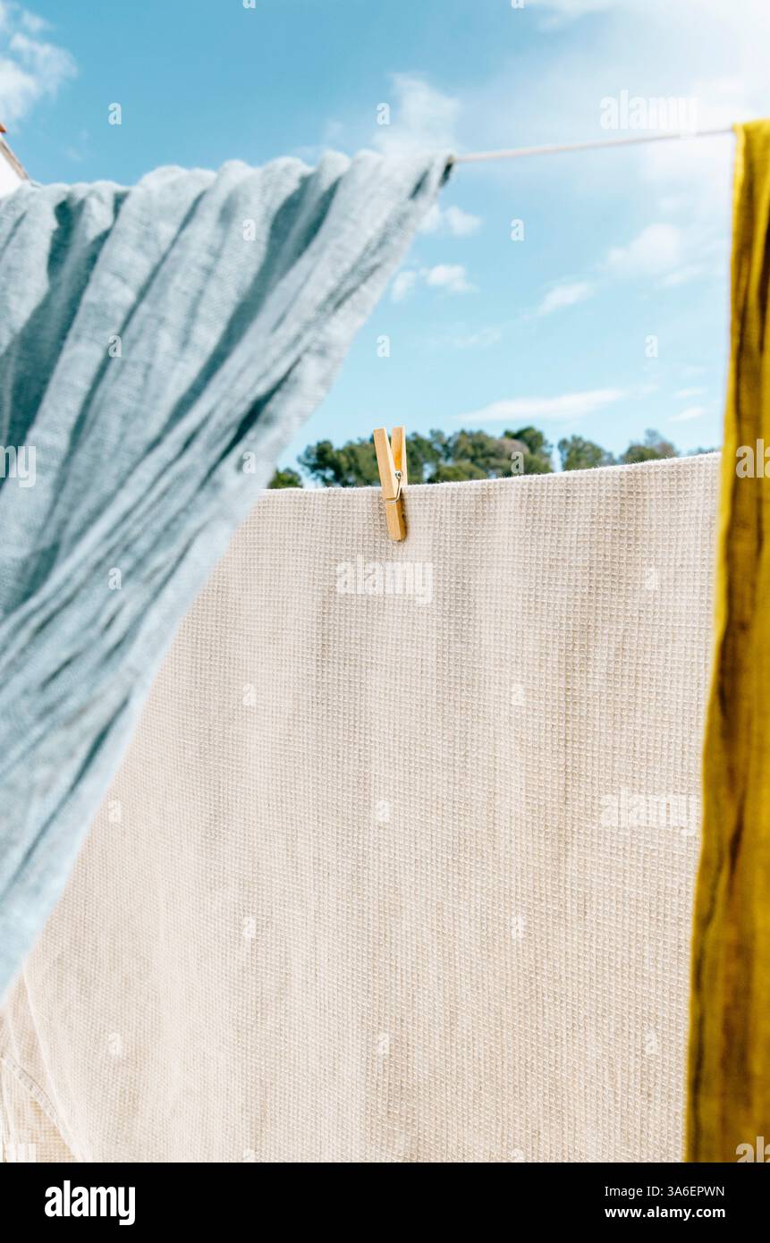 I capi di lino si asciugano all'aria sulla linea di abbigliamento in una giornata di sole e brezza Foto Stock