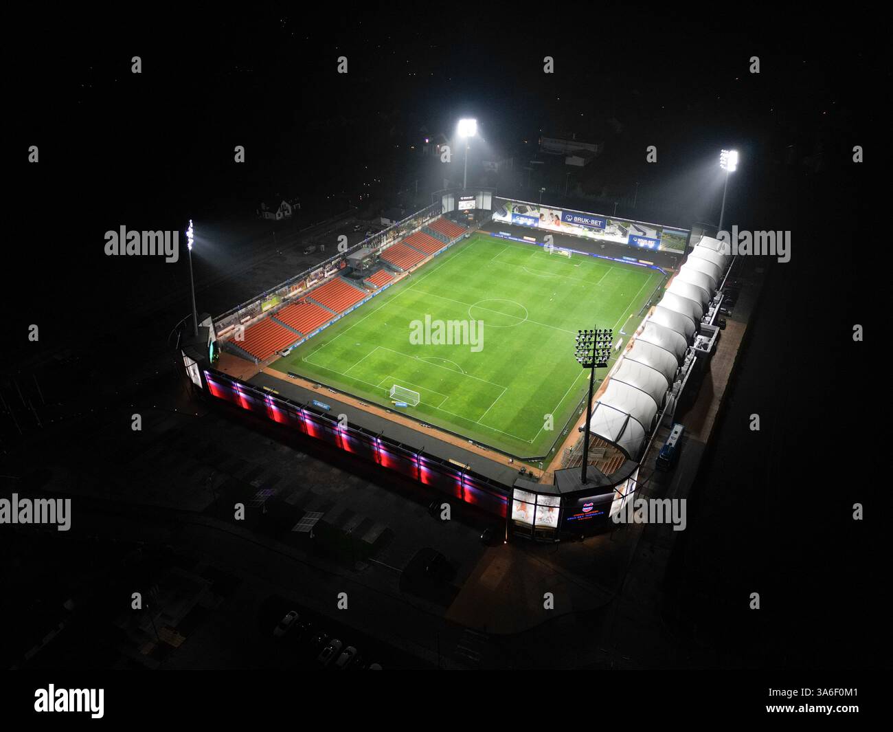 Vista aerea notturna dello Stadion Bruk-Bet Termalica Nieciecza, illuminato da proiettori. Lo stadio è illuminato. Foto Stock