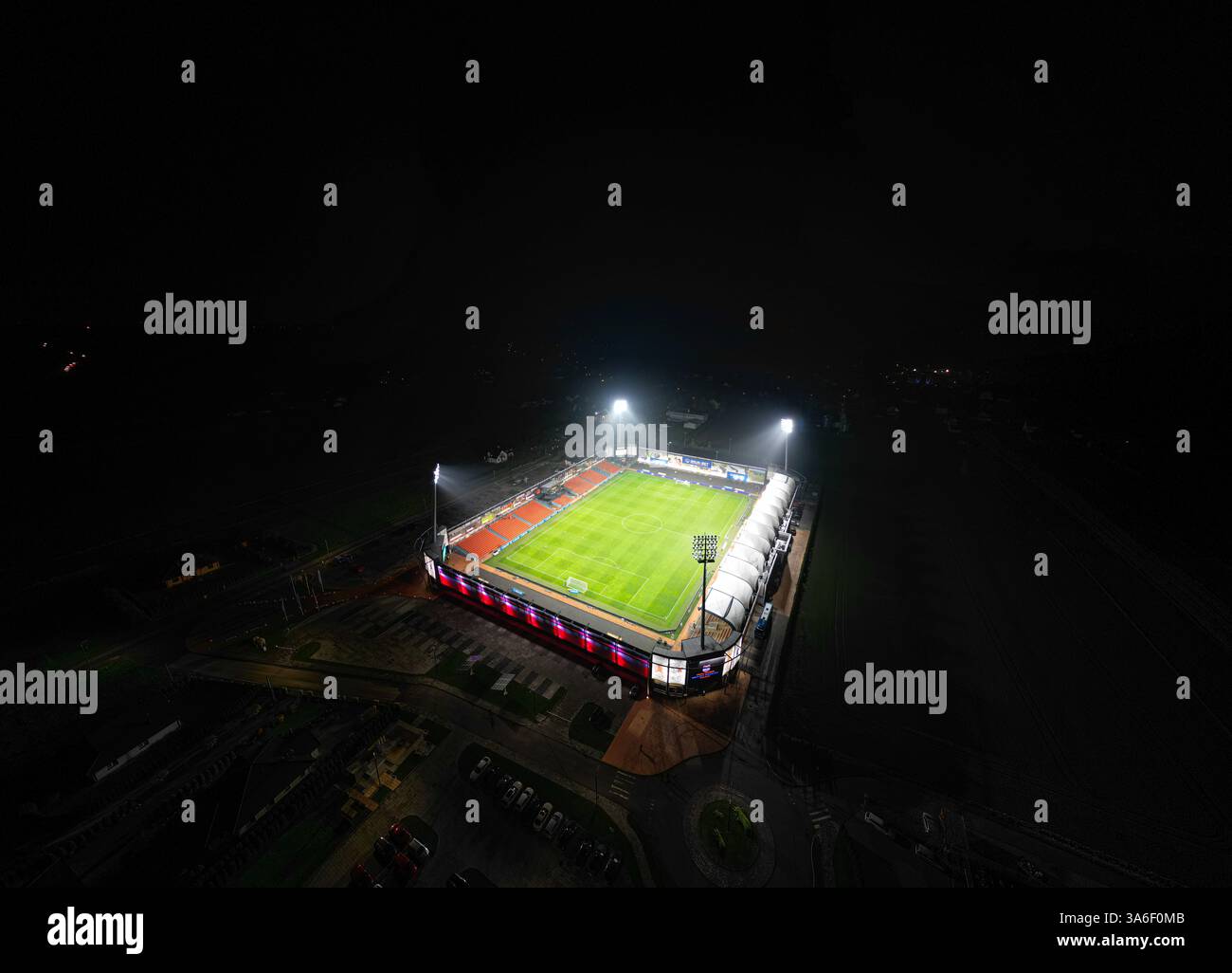 Vista aerea notturna dello Stadion Bruk-Bet Termalica Nieciecza, illuminato da proiettori. Lo stadio è illuminato. Foto Stock