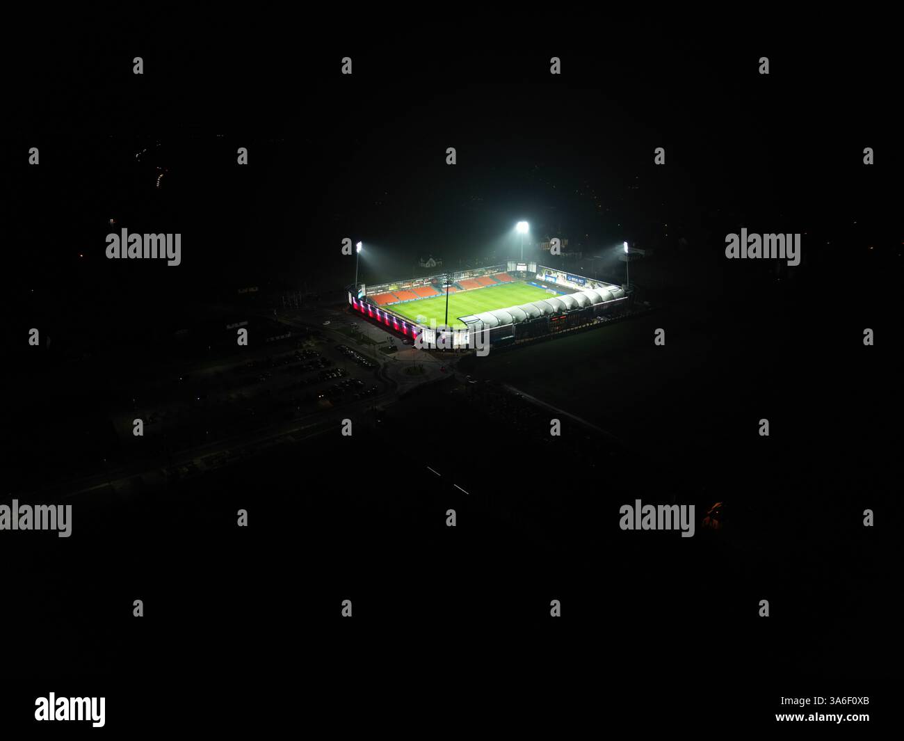 Vista aerea notturna dello Stadion Bruk-Bet Termalica Nieciecza, illuminato da proiettori. Lo stadio è illuminato. Foto Stock
