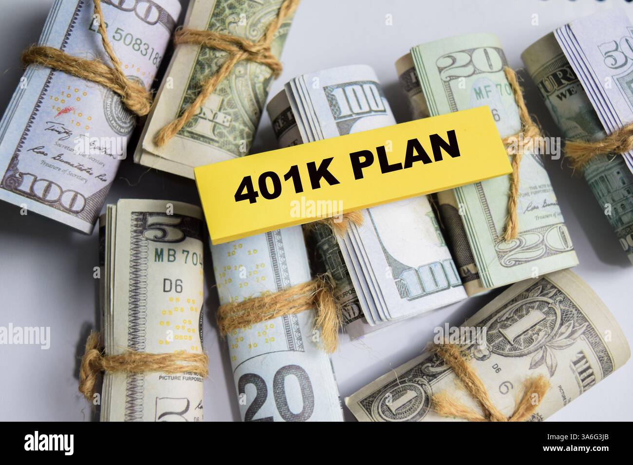 Concetto di piano 401K scrivere su appiccicose e banconote in dollari isolate su un tavolo in legno. Foto Stock