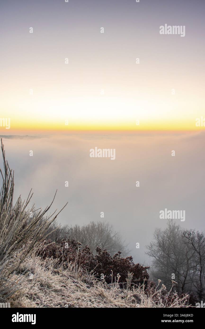 Freddo paesaggio invernale, alba sull'ansa della Mosella con vista sulla valle, completamente ricoperta di nebbia. Bremm, Mosella, Germania, Europa Foto Stock