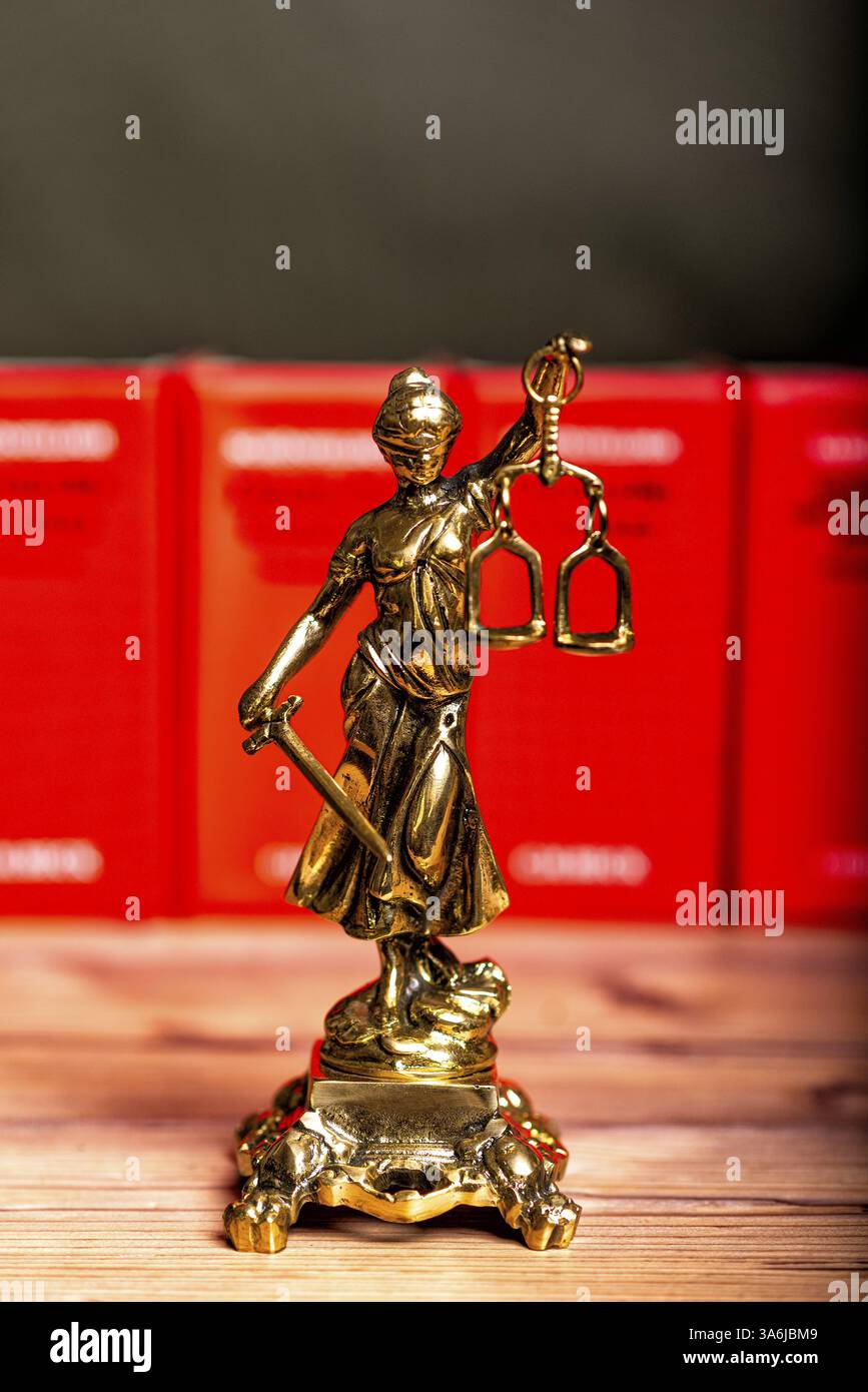 Statua di Lady Justice, dea Justitia, sulla scrivania dell'ufficio di un avvocato su libri Foto Stock