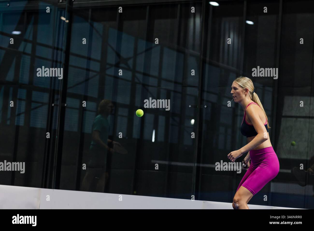 Giocando a tennis in padel, donna che si concentra sulla palla in arrivo in una struttura sportiva, spazio fotocopie Foto Stock
