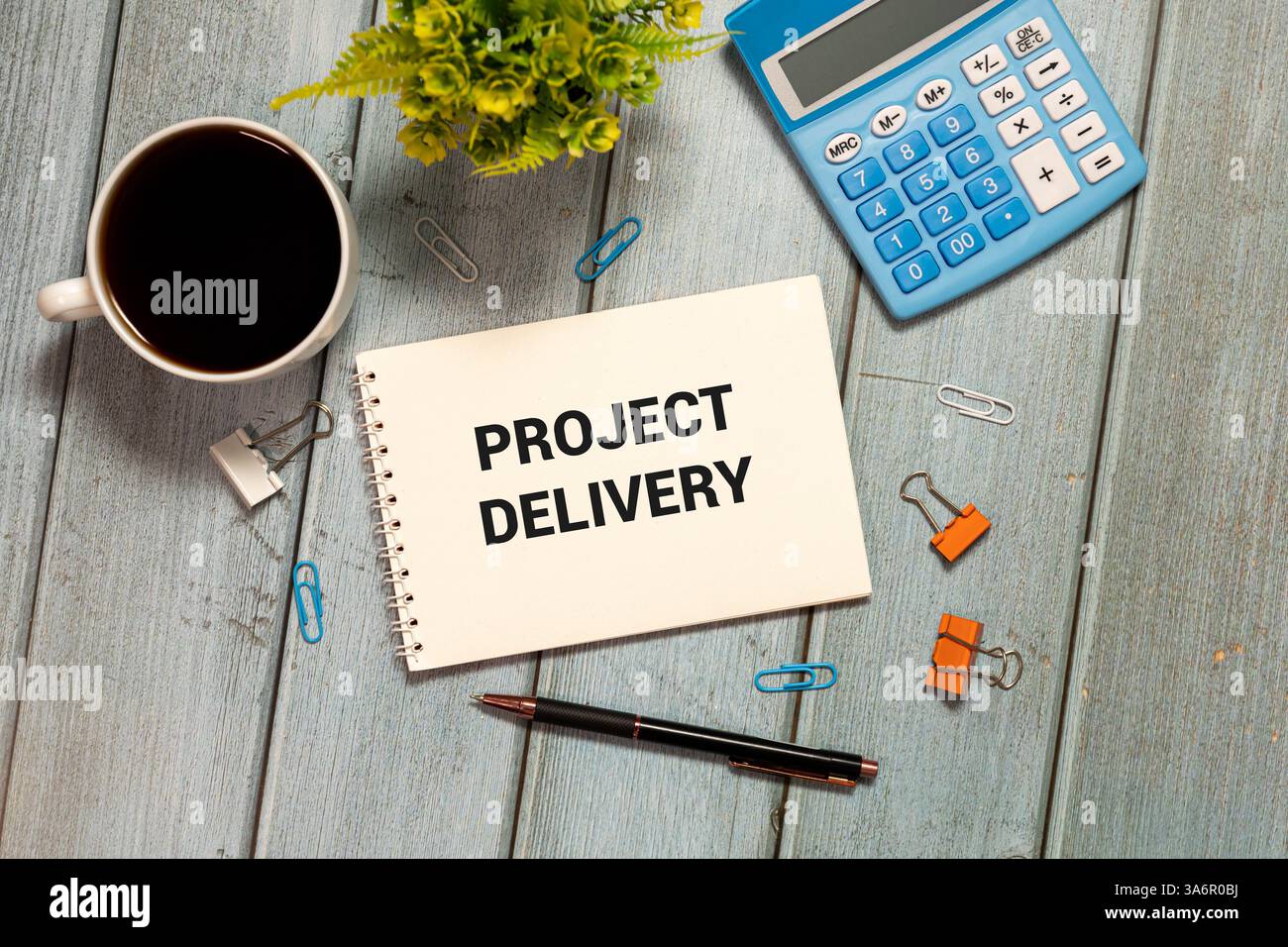 LA CONSEGNA DEI PROGETTI è scritta in un documento sulla scrivania dell'ufficio con accessori per ufficio, diagramma e tastiera Foto Stock