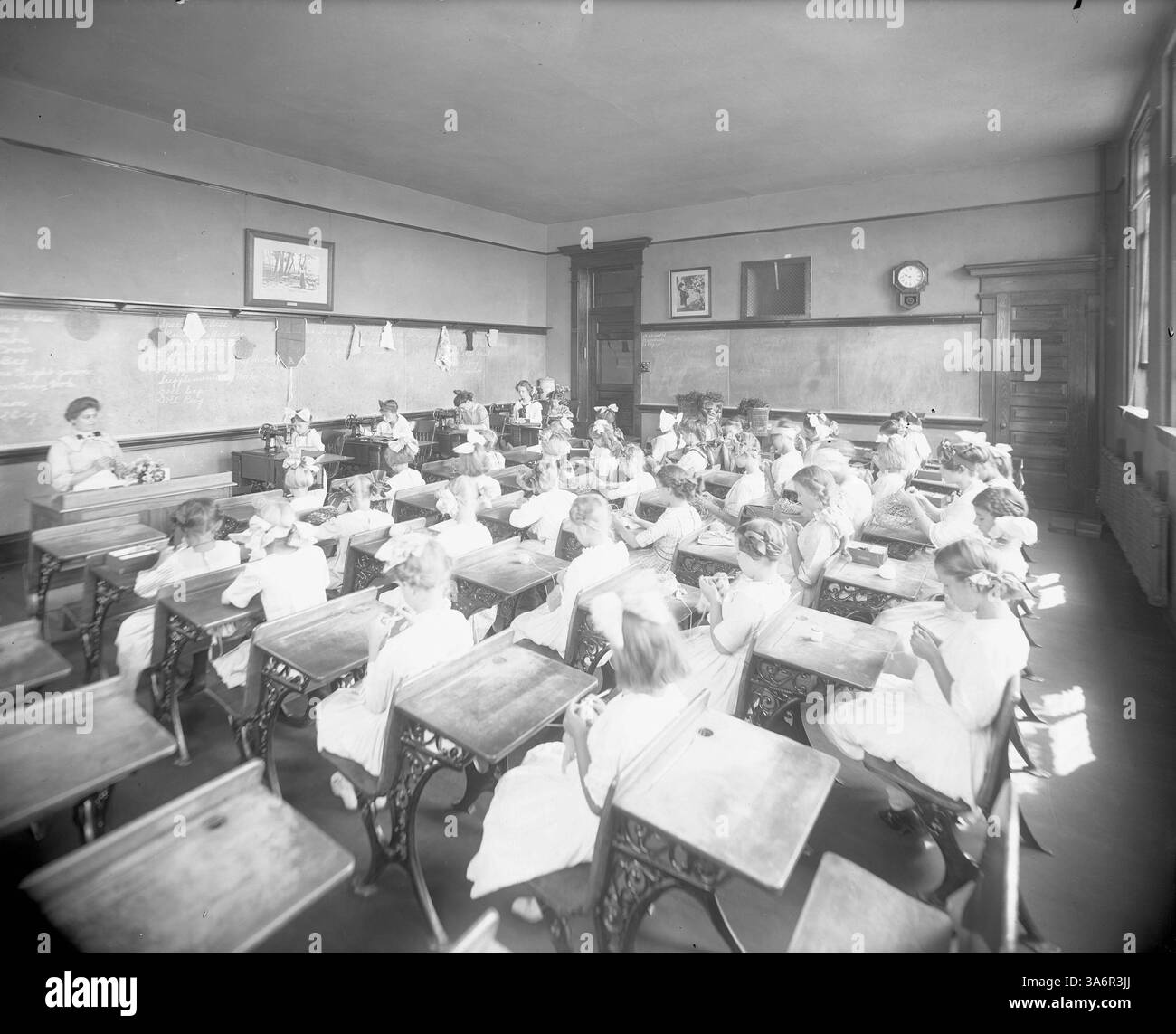L'aula della Old Bryant School è mostrata in questa immagine, con una lezione di cucito. La Bryant School originale fu rinominata Warrington nel 1927. Foto Stock