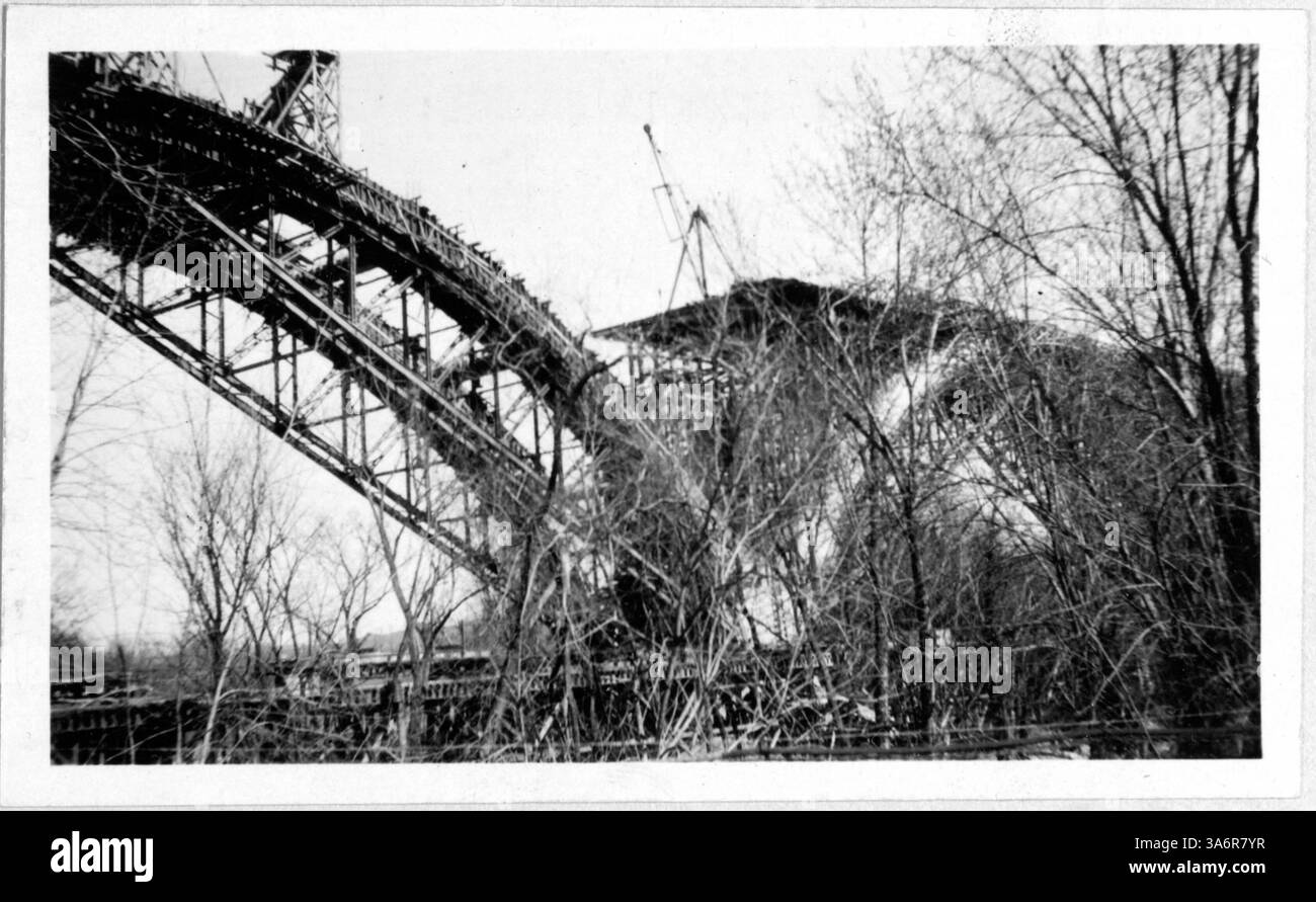 La costruzione del ponte Mendota è in corso, con un arco già in corso. Gli inizi della carreggiata sono visibili in cima all'arco, parzialmente oscurati dai rami degli alberi. Foto Stock