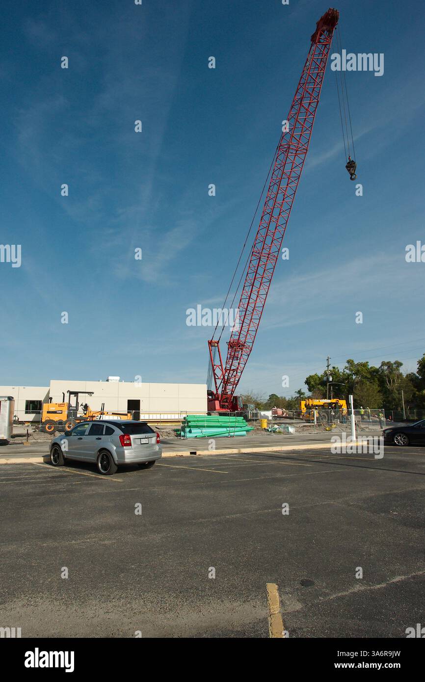 Vista della gru a traliccio rossa dal parcheggio con una palma a sinistra e diversi edifici sullo sfondo. Solo per uso editoriale, 22 marzo 2025 S. Foto Stock