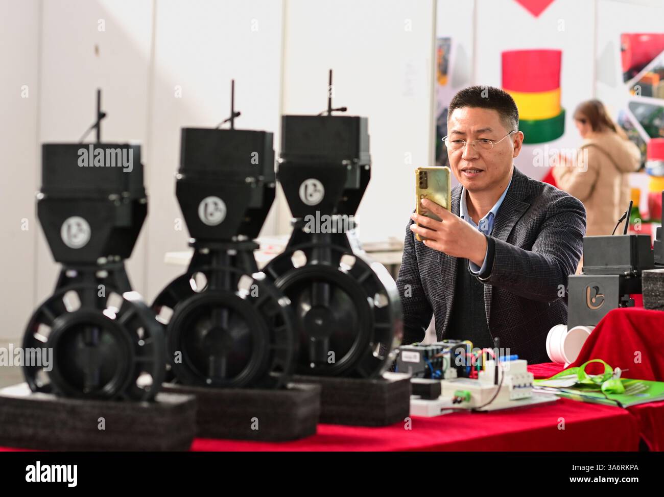 HOHHOT, CINA - 26 MARZO 2025 - Un visitatore guarda una valvola a farfalla elettrica per un'irrigazione intelligente alla 36esima fiera agricola della Mongolia interna Foto Stock