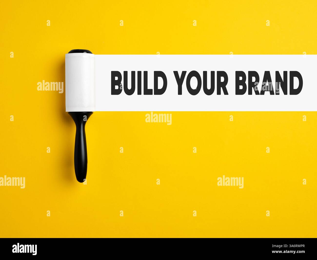 Branding, creazione del marchio e concetto di gestione del marchio. Rullo di lanugine con traccia bianca su sfondo giallo con il messaggio Crea il tuo marchio. Foto Stock