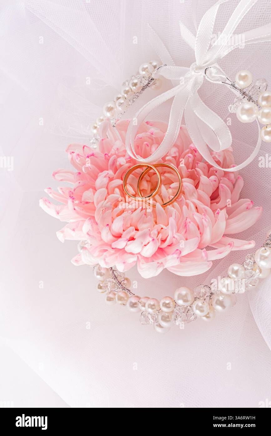 Una decorazione elegante di perle e nastri nell'acconciatura della sposa su un velo bianco con un grande fiore rosa. Vista verticale. concetto del matrimonio Foto Stock