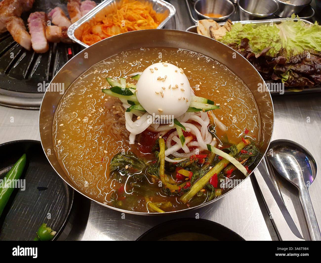 Piatti tradizionali coreani (Mul Naengmyeon - zuppa fredda di spaghetti) con brodo freddo, cetriolo a fette, ravanello, giovane Kimchi di ravanello estivo, un uovo sodo. Foto Stock