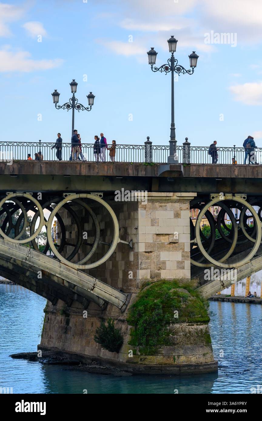 Colonne di pietra e strutture di supporto in metallo nel ponte Triana, ufficialmente noto come ponte Isabel II. Foto Stock