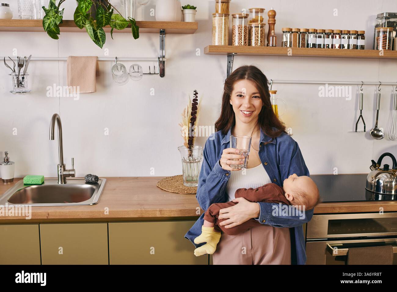 Una madre amorevole condivide un momento tenero con il suo bambino in una cucina calda e invitante. Foto Stock