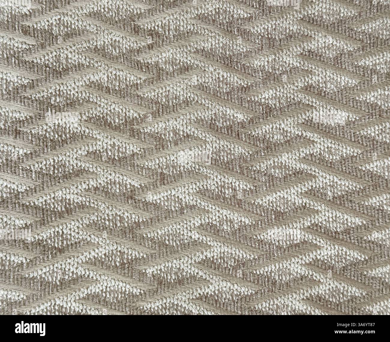 Primo piano di tessuto dorato con motivo a filo ondulato. Tessuto beige dorato con tessitura a chevron, fondo senza cuciture. Foto Stock