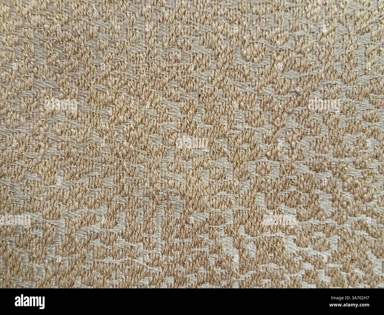 Primo piano di un tessuto decorativo dorato con increspature rotonde o motivi a nuvole. Tessuto dorato bronzo con fondo senza cuciture. Foto Stock
