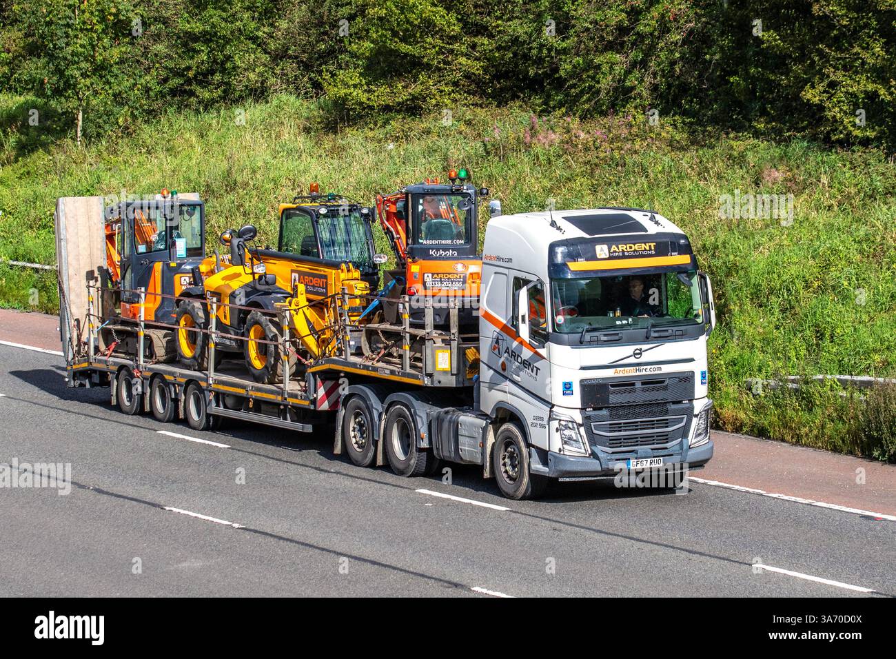 Soluzioni Ardent Hire: Società di noleggio di attrezzature edili, specialista nel noleggio di attrezzature multicategoria. Volvo HGV con escavatore Kubota; viaggiare sull'autostrada M6, Regno Unito Foto Stock