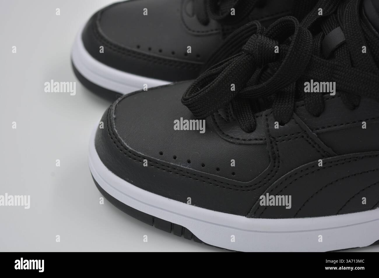 Belle scarpe sportive per giovani, stivali neri con suola rigida bianca su un plast bianco. Semistivali caldi in similpelle con isolamento. Foto Stock