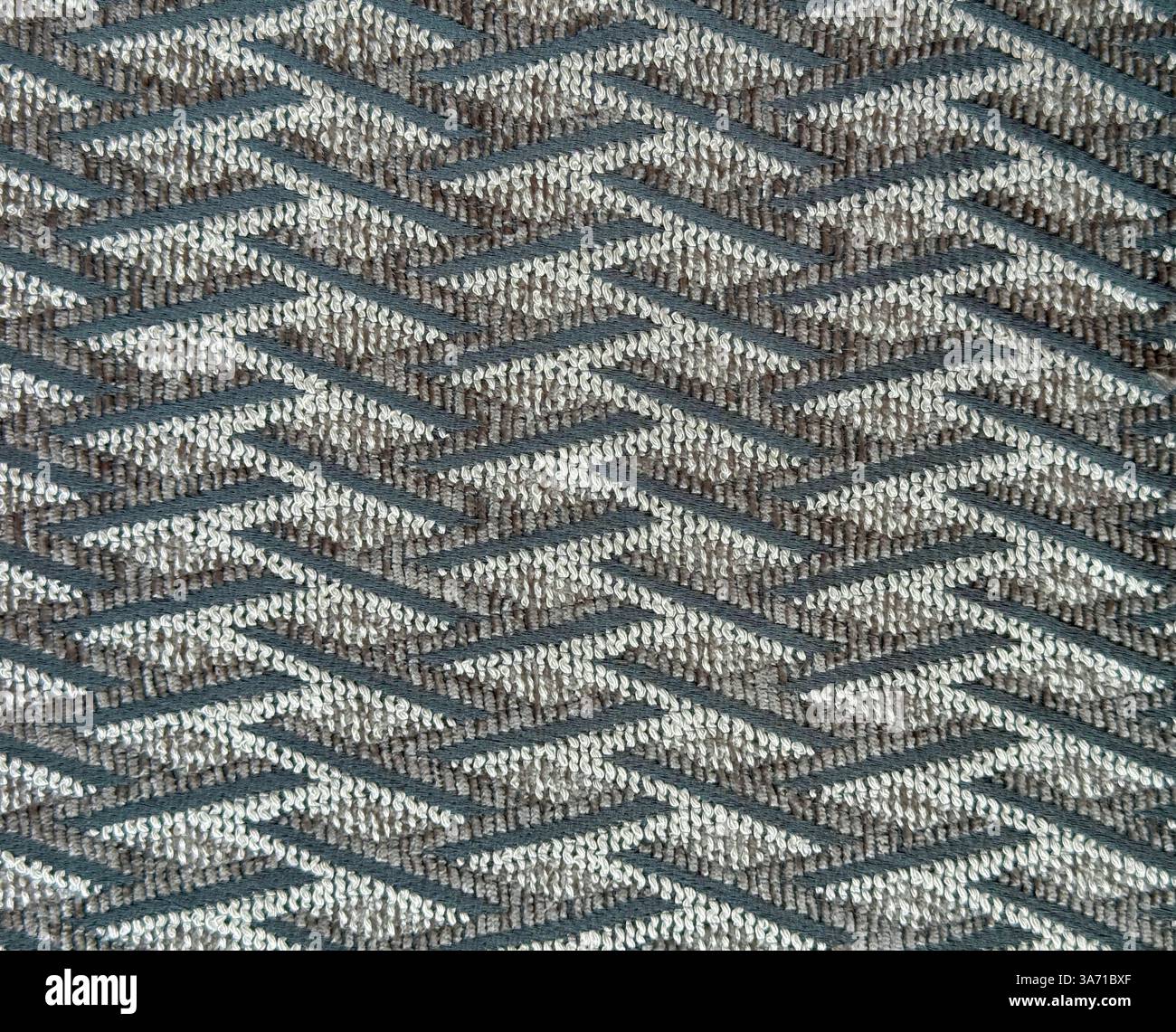 Primo piano di tessuto blu e grigio con motivo a filo ondulato. Tessuto beige grigio scuro con trama a chevron, fondo senza cuciture. Foto Stock