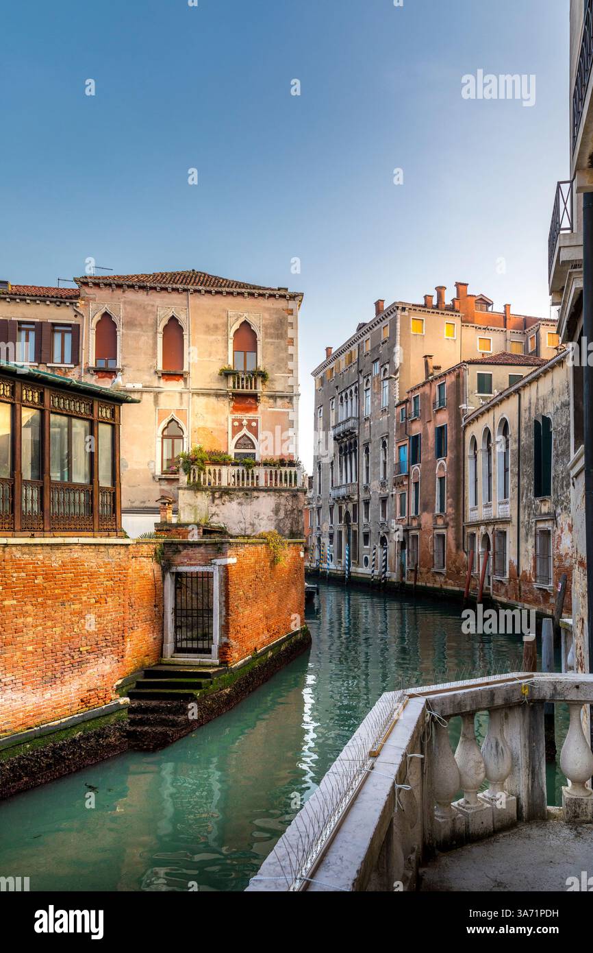 Venezia, Italia - 5 febbraio 2025: Uno stretto canale a Venezia, Italia, fiancheggiato da edifici. Un balcone si affaccia sull'acqua Foto Stock