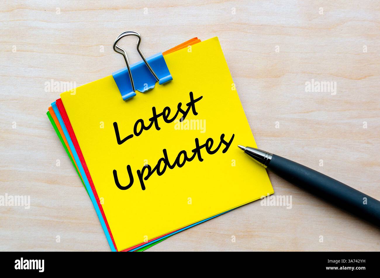 Testo degli ultimi aggiornamenti su blocco note giallo. Concetto di aggiornamento aziendale. Foto Stock