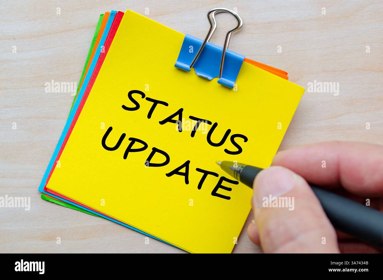 Testo aggiornamento stato su blocco note giallo. Aggiornamenti aziendali e informazioni sullo stato. Foto Stock