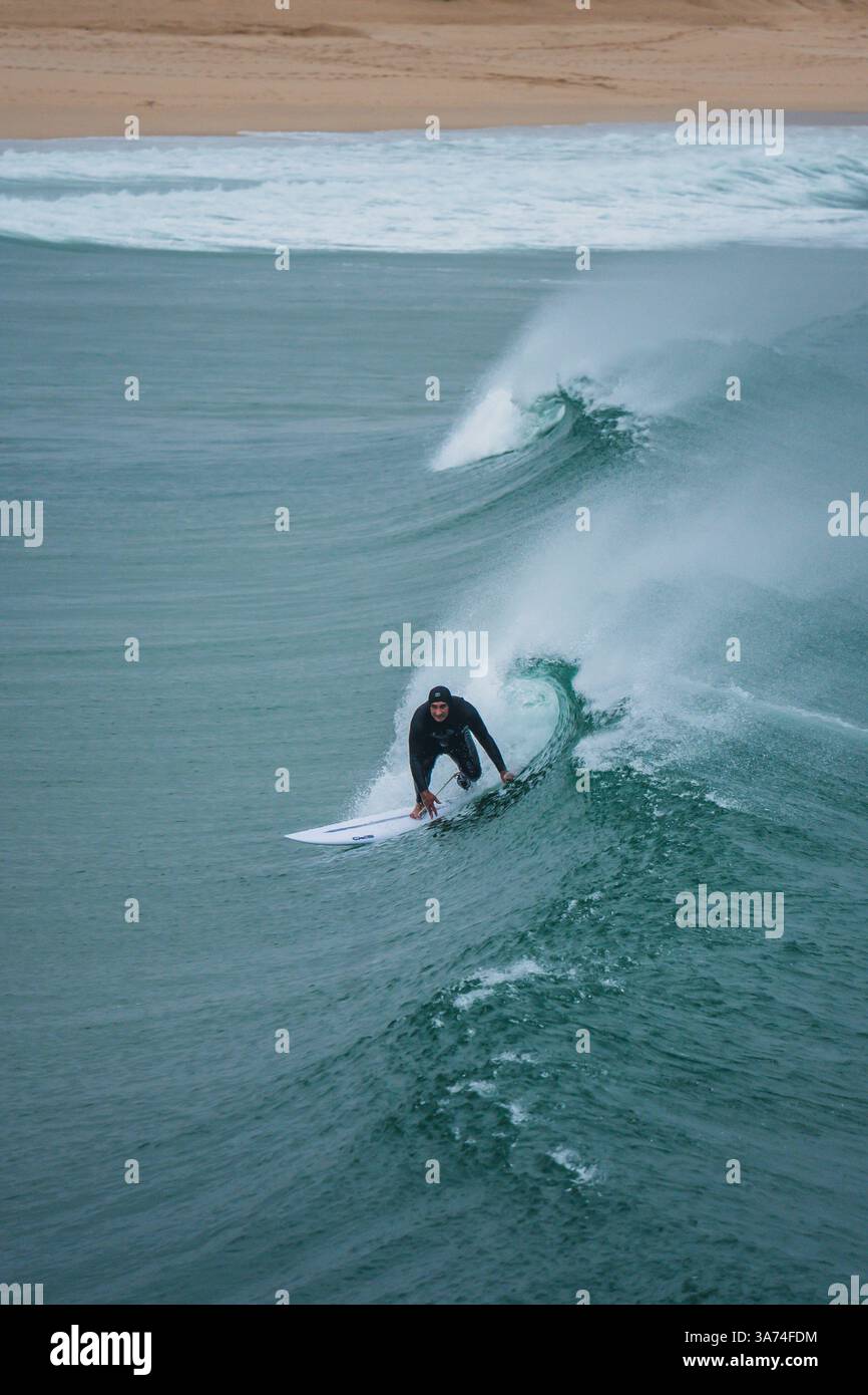 Surfisti nella famosa spiaggia di Supertubos, Peniche, Portogallo Foto Stock
