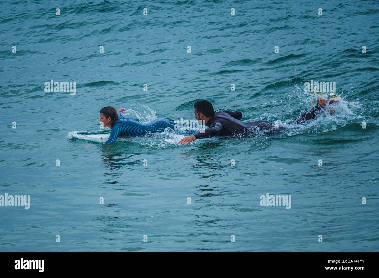 Surfisti nella famosa spiaggia di Supertubos, Peniche, Portogallo Foto Stock