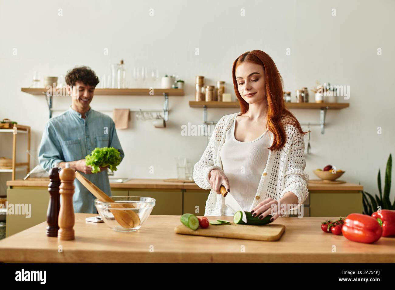 Una coppia amorevole condivide un momento di gioia per preparare un pasto, circondato da ingredienti freschi e calore. Foto Stock