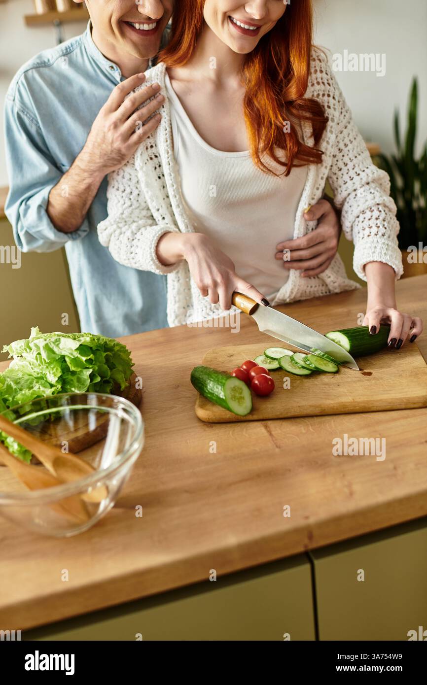 La giovane coppia ama cucinare insieme di qualità, circondati da calore e affetto a casa. Foto Stock