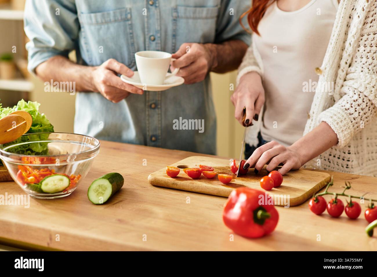 Due giovani amanti condividono un momento tenero mentre preparano un pasto, favorendo la connessione e la gioia. Foto Stock