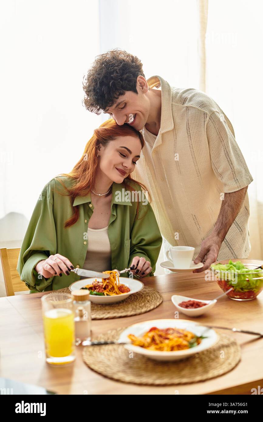 Una coppia amorevole condivide un momento emozionante a casa mentre si gusta un pasto delizioso. Foto Stock