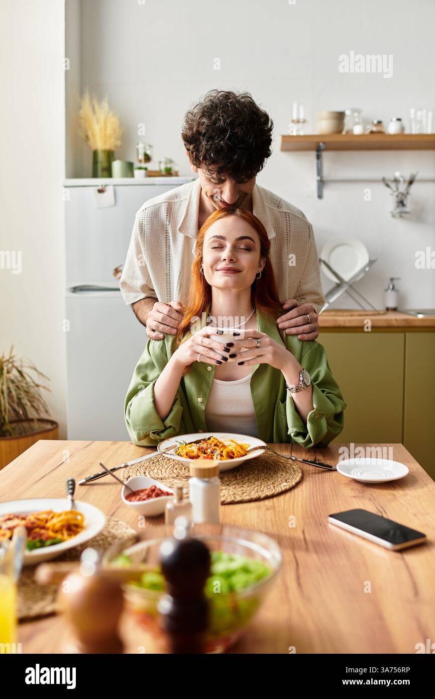 Una giovane coppia si gode un momento caldo insieme con un pasto delizioso. Foto Stock