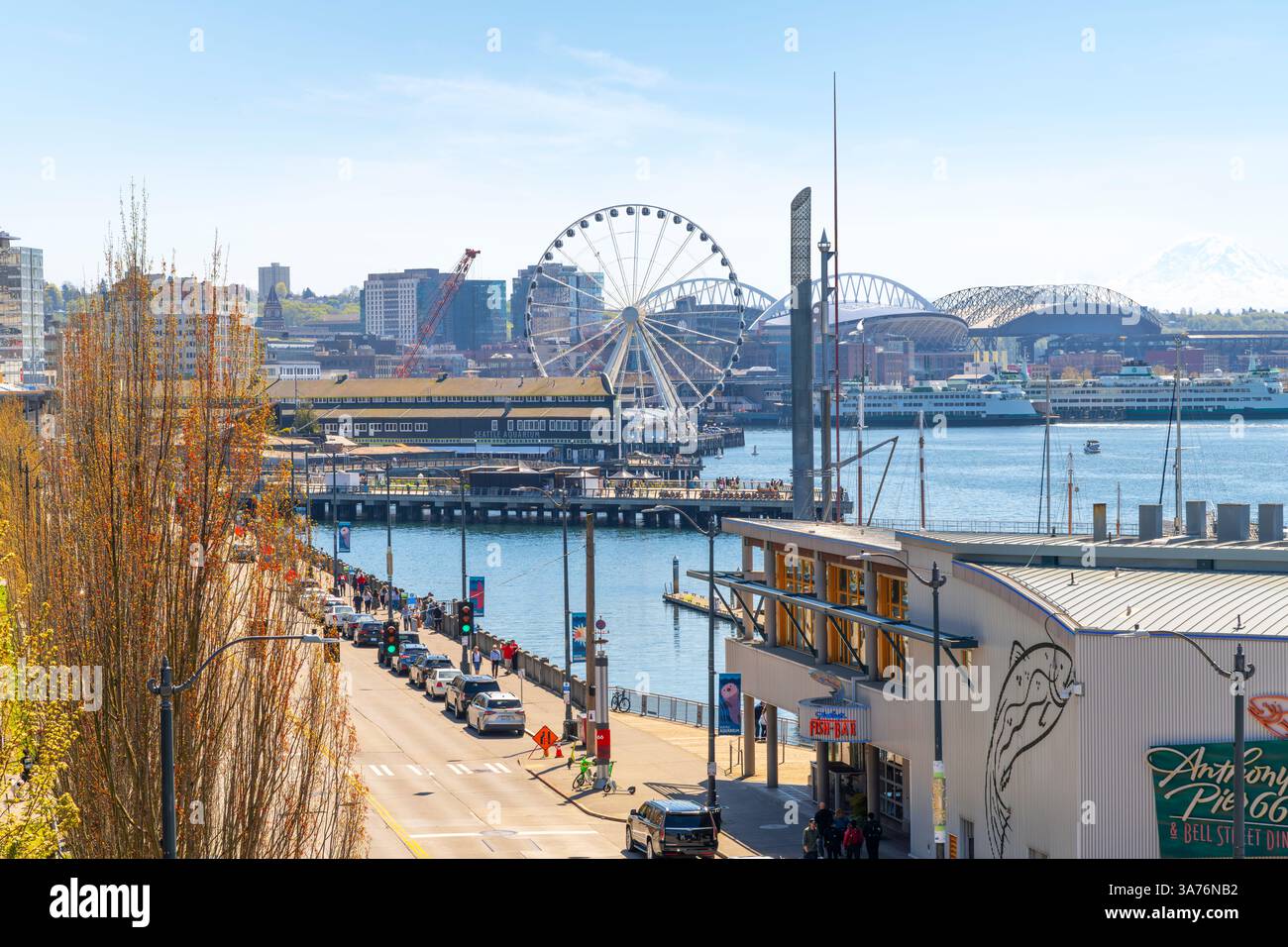 Il lungomare di Seattle lungo il Puget Sound al Pier 55 con la Great Wheel, l'acquario, il Lumen Field e il Mount Rainier in vista, Seattle Washington. Foto Stock