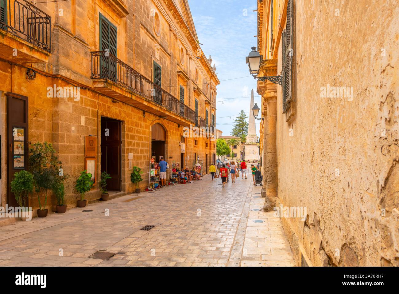 Una stretta strada di negozi e caffetterie che conduce alla piazza Placa la Catedral nella città vecchia medievale di Ciutadella de Menorca. Foto Stock