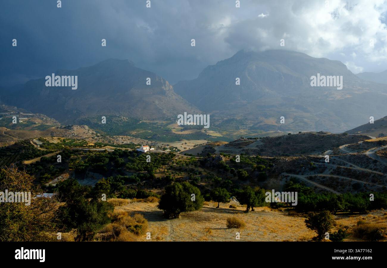 Ecco una didascalia per l'immagine: Una vista panoramica del paesaggio montuoso di Creta, Grecia, sotto un cielo drammatico. L'immagine acquisisce il robusto terr Foto Stock