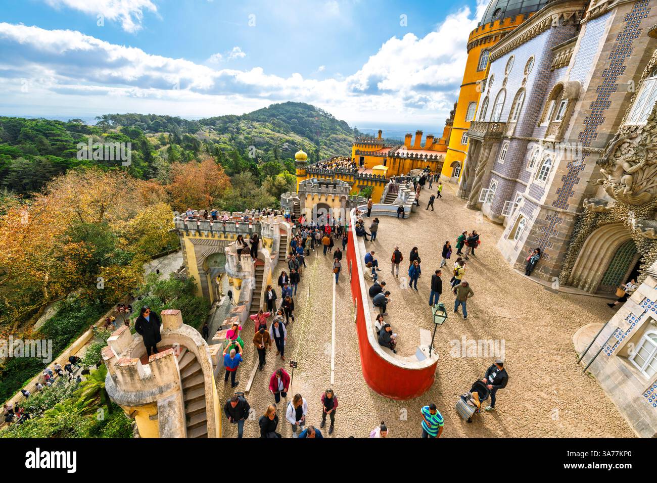 Il colorato Palazzo da pena, rosso e giallo, è pieno di turisti sulle terrazze a diversi livelli delle colline di Sintra, Portogallo. Foto Stock
