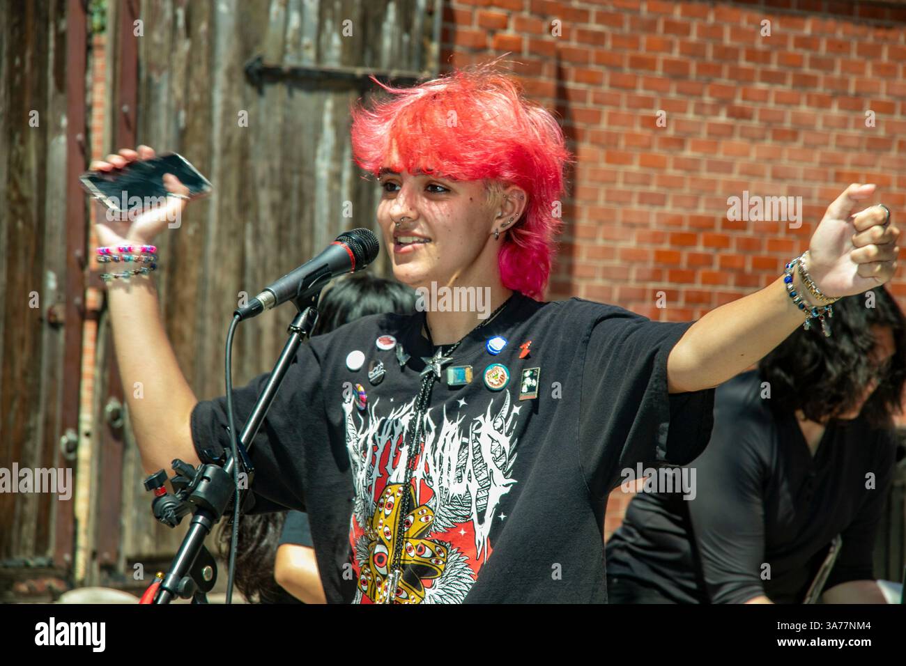 Vestito con una parrucca rossa, un annunciatore presiede una manifestazione gay Pride a Santa Ana, CALIFORNIA. Foto Stock