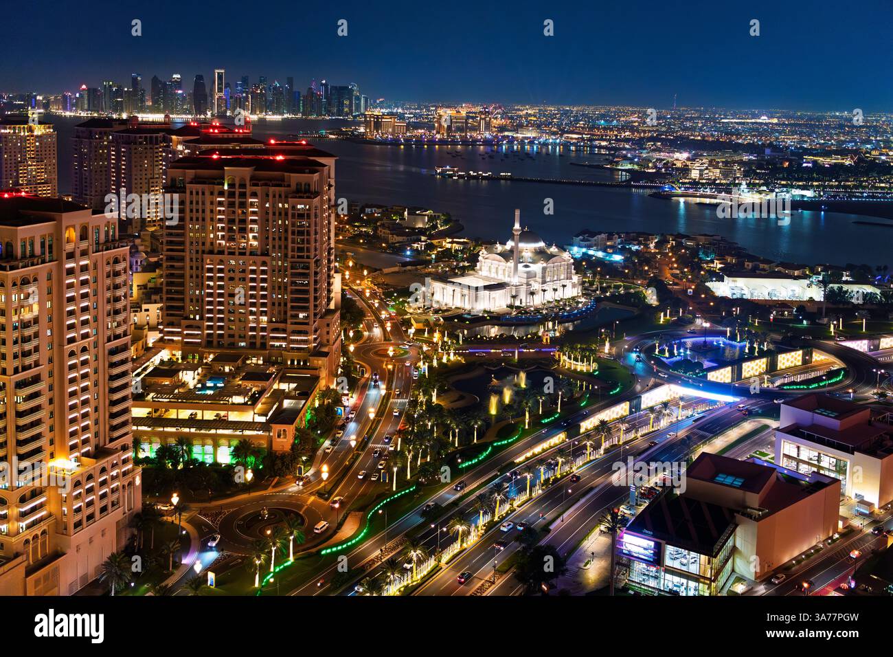Vista serale dall'alto della moschea illuminata dello sceicco Hamad bin Jassim a Pearl Island, con la vista dello skyline del centro cittadino alle spalle, a Doha in Qatar. Foto Stock