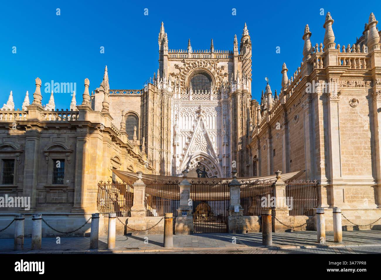 Uno degli ingressi e un piccolo cortile recintato della Cattedrale di Siviglia nel centro storico della città andalusa di Siviglia, Spagna. Foto Stock