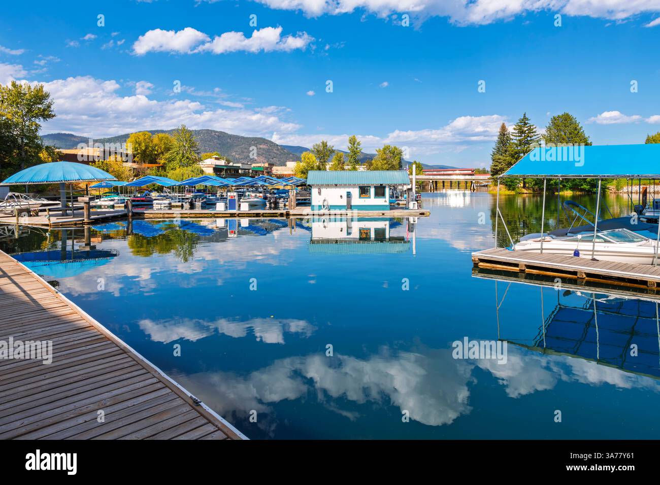 Le barche in scivoli attraccano al porticciolo di Sandpoint, con la strada principale della piccola città di Sandpoint Idaho alle spalle, sul lago Pend Oreille nell'Idaho settentrionale Foto Stock