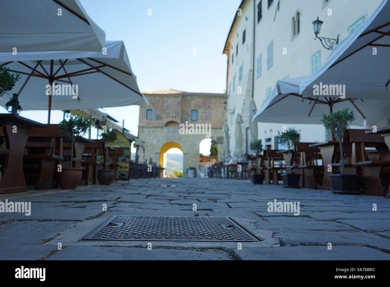 Il caffè all'aperto di Motovun con ombrelloni e tavoli e sedie in legno dal pavimento Foto Stock