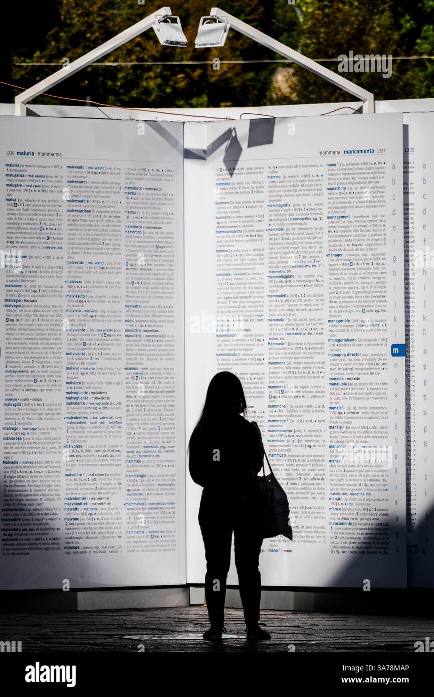 La conoscenza e gli uomini. Un grande dizionario che interagisce con le persone che passano. Foto Stock